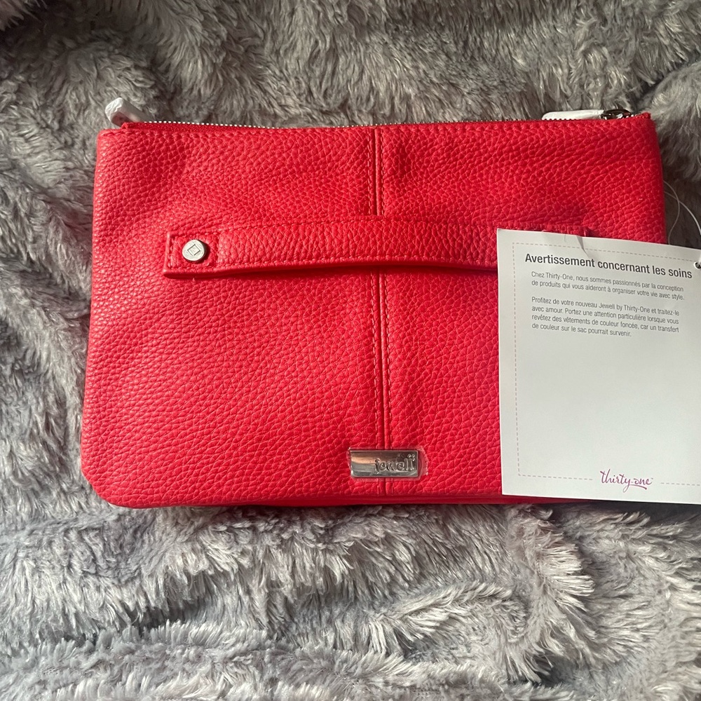 Brand new, with tags Thirty-one clutch.